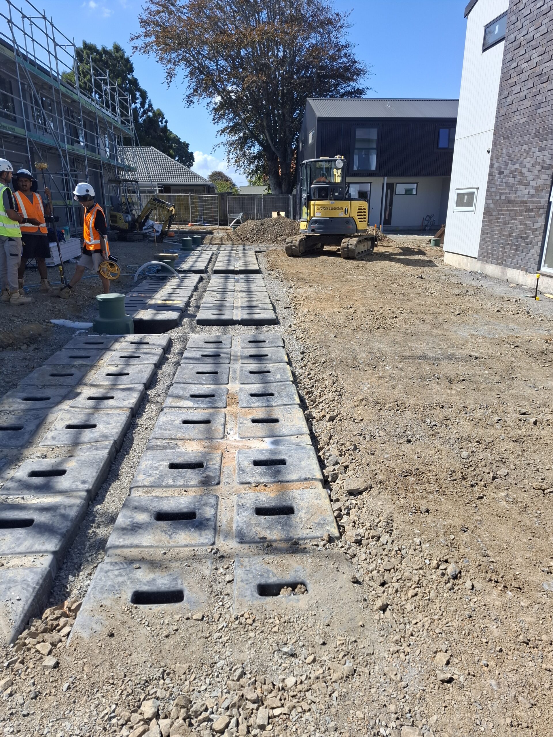 StormSlab tanks laid in a shallow trench alongside townhouses under construction at a Manukau development