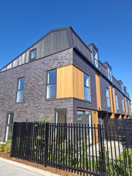 Completed brick and cedar townhouses at the GJ Gardner Manukau multi-unit development
